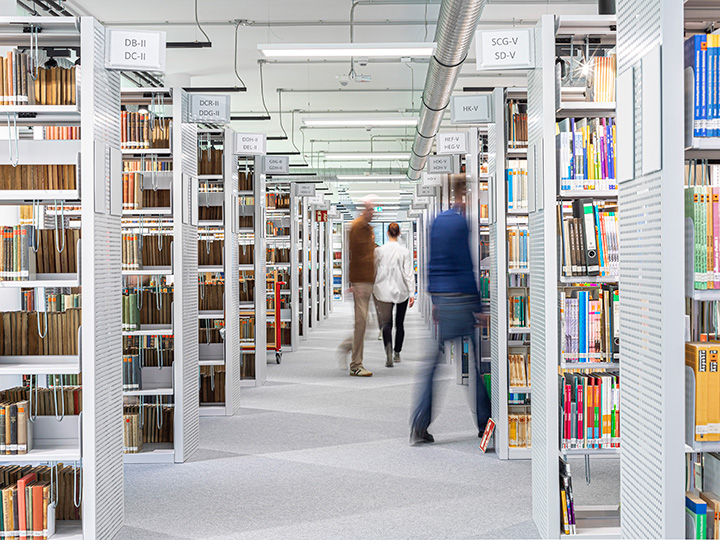 View of a modern library with rows of light-coloured bookshelves