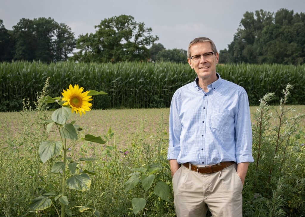 Ein Mann mit Händen in den Hosentaschen schaut in die Kamera